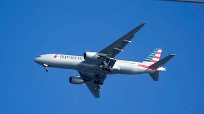 An American Airlines Boeing 777 is framed by utility wires as it prepares to land at Miami International Airport, Wednesday, Jan. 27, 2021, in Miami.