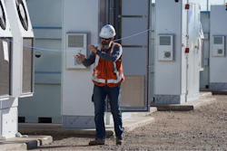 Workers do checks on battery storage pods at Orsted's Eleven Mile Solar Center lithium-ion battery storage energy facility Thursday, Feb. 29, 2024, in Coolidge, Ariz.
