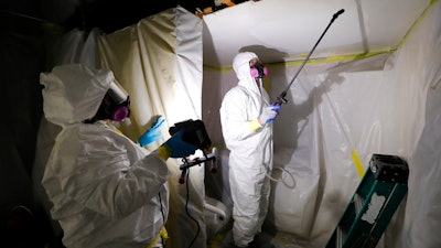 Asbestos Removal Technologies Inc. staff work on asbestos abatement in Howell, Mich., Oct. 18, 2017.