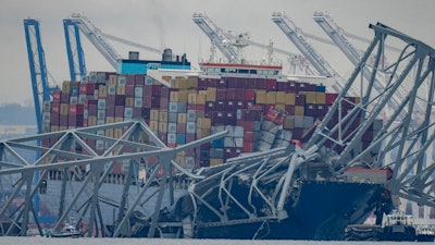 The container ship Dali, owned by Grace Ocean PTE, rests against wreckage of the Francis Scott Key Bridge in the Patapsco River on Wednesday, March 27, 2024, as seen from Pasadena, Md.