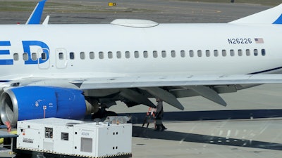 A Medford Jet Center worker walks under a United Boeing 737-824 that landed at Rogue Valley International-Medford Airport from San Francisco with a missing panel Friday, March 15, 2024, in Medford, Ore.