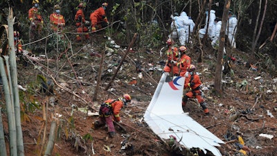 In this photo released by Xinhua News Agency, search and rescue workers search through debris at the China Eastern flight crash site in Tengxian County in southern China's Guangxi Zhuang Autonomous Region on March 24, 2022.