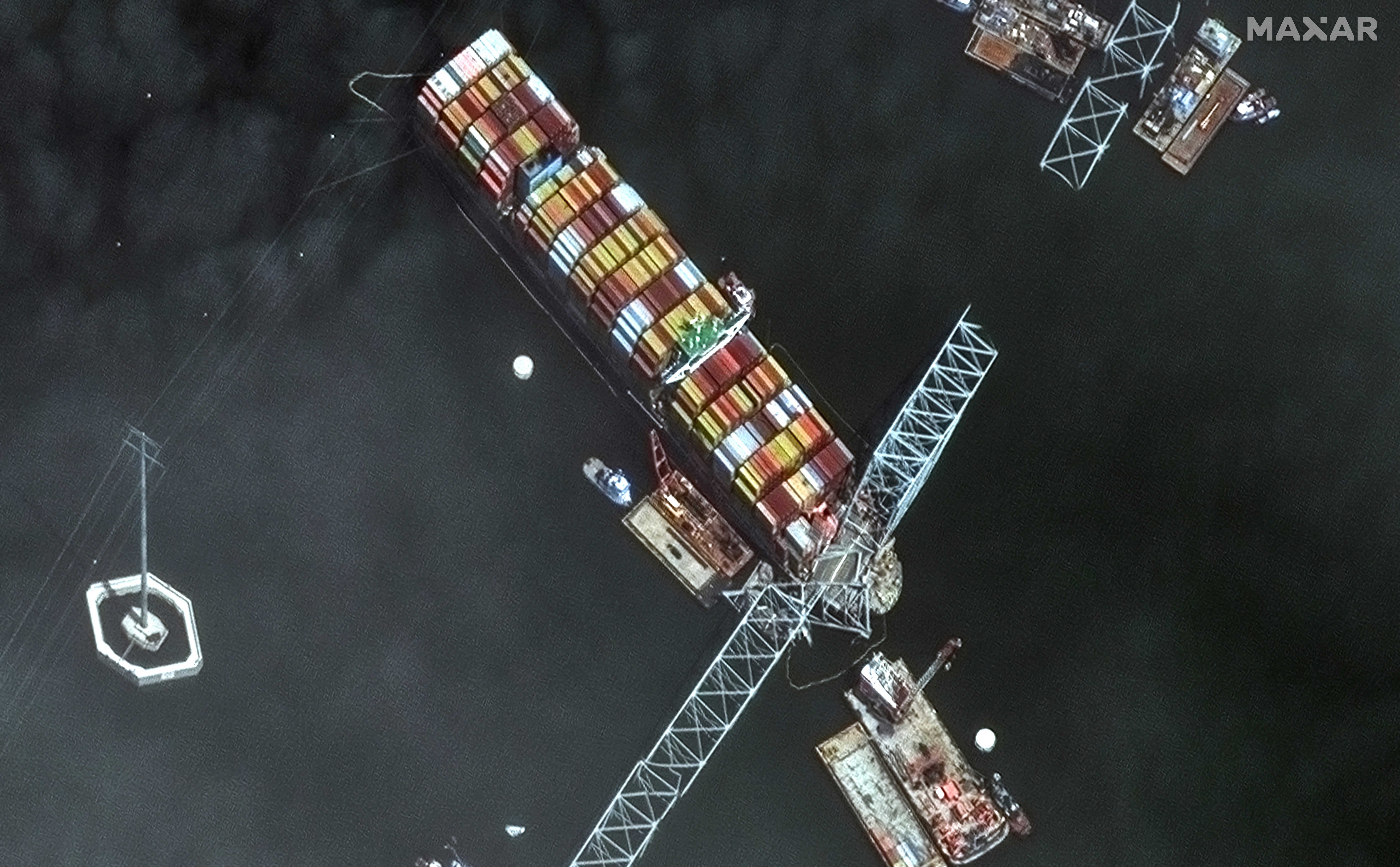 Satellite image showing the bow of the container ship Dali underneath sections of the fallen Francis Scott Key Bridge, Baltimore, April 8, 2024.