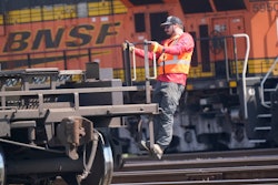 A worker rides a rail car at a BNSF rail crossing in Saginaw, Texas, Sept. 14, 2022.