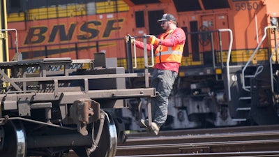 A worker rides a rail car at a BNSF rail crossing in Saginaw, Texas, Sept. 14, 2022.