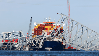 The collapsed Francis Scott Key Bridge lay on top of the container ship Dali, Monday, April 15, 2024, in Baltimore.