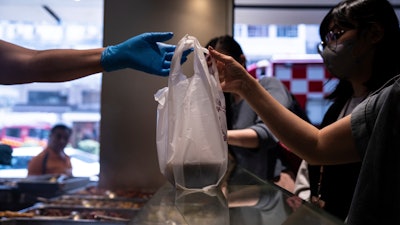 A customer collects a takeaway food plastic bag at Kuen Fat Kitchen in Hong Kong, April 10, 2024.