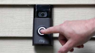 A person pushes the doorbell on his Ring doorbell camera, July 16, 2019, at his home in Wolcott, Conn.