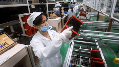 A worker checks solar panels at a factory in Jiujiang in central China's Jiangxi province on March 16, 2018.