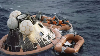 Navy personnel retrieve the crew from the Apollo 11 return capsule after splashdown on July 24, 1969.