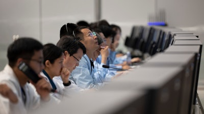 In this photo released by Xinhua News Agency, technical personnel work at the Beijing Aerospace Control Center (BACC) in Beijing, Sunday, June 2, 2024. A Chinese spacecraft landed on the far side of the moon Sunday to collect soil and rock samples that could provide insights into differences between the less-explored region and the better-known near side.