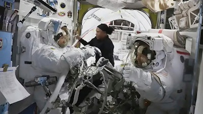 In this photo provided by NASA, astronaut Jeanette Epps (center) is pictured assisting NASA astronauts Mike Barratt (left) and Tracy Dyson (right) inside the Quest airlock.