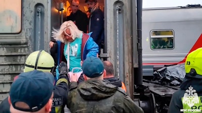 Russian Emergency Ministry workers help a woman to leave a damaged carriage on the Inta - Ugolny stretch to Komi in the northern republic of Komi, Russia.