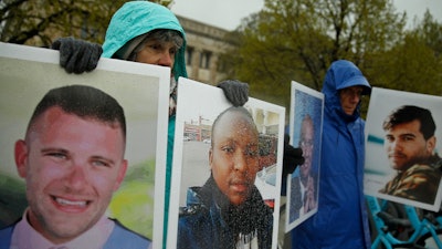 Protesters hold photographs of victims, including Melvin Riffel, left, of the 2019 Ethiopian Airlines plane crash, outside Boeing's annual shareholders meeting in Chicago on April 29, 2019.