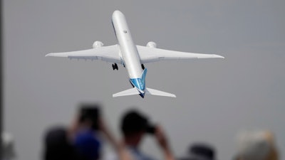 A Boeing 777X plane takes off at the Farnborough Air Show fair in Farnborough, England, on July 18, 2022.
