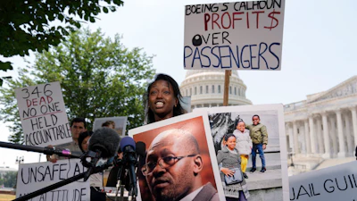 Zipporah Kuria of England, lost her father Joseph Kuria, one of the crash victims of a Boeing 737 MAX8 in Ethiopia, holds his photographs as she speaks during a news conference on Capitol Hill.