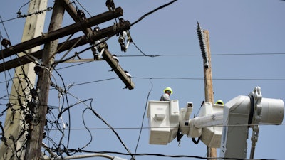 A brigade from the Electric Power Authority repairs distribution lines damaged by Hurricane Maria in the Cantera community of San Juan, Puerto Rico.