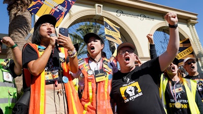 SAG-AFTRA captains Iris Liu, left, and Miki Yamashita, center, and SAG-AFTRA chief negotiator Duncan Crabtree-Ireland lead a cheer for striking actors outside Paramount Pictures studio, Nov. 3, 2023, in Los Angeles.