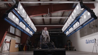 A seated dummy on stage in testing facility.