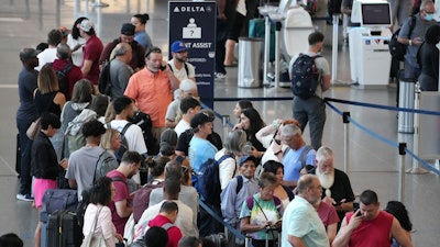 Passengers wait in line for assistance at the Delta Terminal at Logan International Airport in Boston.