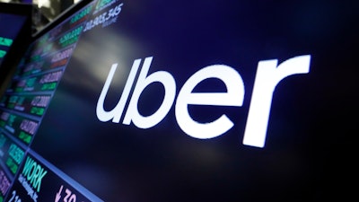 The Uber logo appears above a trading post on the floor of the New York Stock Exchange.