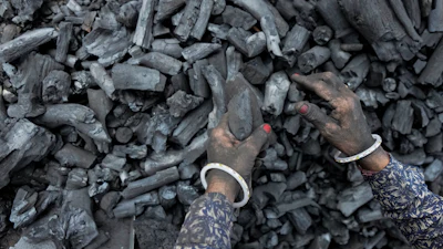 A woman works at a coal depot in Ahmedabad, India.