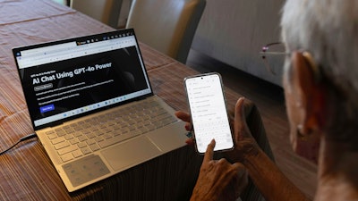 Barbara Winston uses a computer and a smartphone at her home in Northbrook, Ill., on Sunday, June 30, 2024, several days after taking an introduction to artificial intelligence class at a local senior center.