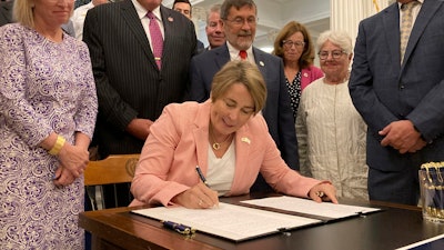 Massachusetts Gov. Maura Healey signs into law a bill that would phase out the use of PFAS, a group of toxic industrial compounds, in firefighters' protective gear, at the Massachusetts Statehouse, Thursday, Aug. 15, 2024, in Boston. The chemical, associated with health problems including several types of cancer, is used in gear to repel water and other substances when fighting a fire.