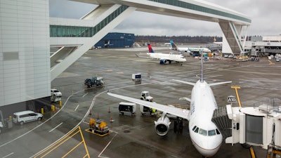 Planes taxi under the aerial passenger walkway at Seattle-Tacoma International Airport.