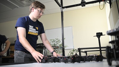 In Yu Gu’s Interactive Robotics Laboratory at WVU, doctoral student Trevor Smith observes Loopy, a multicellular robot that is learning to respond organically and autonomously to its environment.