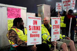 Solomon Hammond, 33, left, and John Olson, 45, right, both toolmakers at Boeing's Renton factory, hold picket signs after union members voted overwhelmingly to reject a contract offer and go on strike Friday, Sept. 13, 2024, outside the company's factory in Renton, Wash.