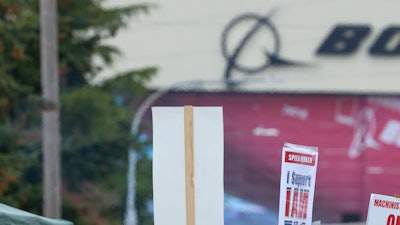 Boeing Machinists Union member Stephanie Corona waves to passing traffic while on the picket line at the Everett plant, Friday, Sept. 13, 2024, in Everett, Wash.