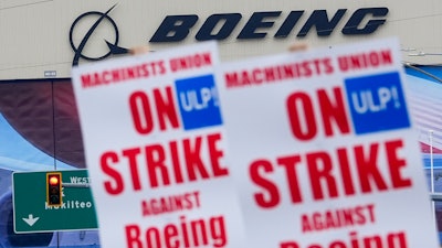 Boeing workers wave picket signs as they strike after union members voted to reject a contract offer, Sunday, Sept. 15, 2024, near the company's factory in Everett, Wash.