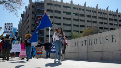 Loveena Watahomigie, right, lead members of the Hualapai Tribe as they march in front of U.S. District Court to try to persuade a federal judge to extend a temporary ban on exploratory drilling for a lithium project Tuesday, Sept. 17, 2024, in Phoenix.
