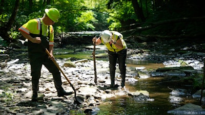 Environmental Protection Agency workers work in Leslie Run in East Palestine, Ohio, June 12, 2024.