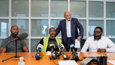 Attorney William Murphy, third from left, speaks during a press conference announcing a class action claim against the owners of the Dali seeking damages for economic losses suffered by Longshoreman Union members, with union members Ryan Hale, Anthony Wynn and Alonzo Key, Thursday, Sept. 26, 2024, in Baltimore.