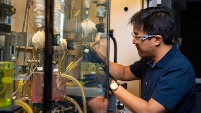 Working at Richland, Wash., Daniel Santosa, a Washington State University doctoral student and scientist at Pacific Northwest National Laboratory, tests a WSU-developed continuous process that turns lignin, a polymer found in plants, into jet fuel.