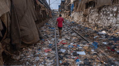 A man walks on a railway track littered with plastic and other waste materials on Earth Day in Mumbai, India, April 22, 2024.