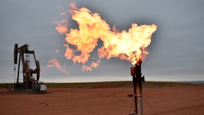 A flare burns natural gas at an oil well in Watford City, N.D.