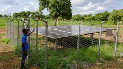 A young man stands by a community radio station solar setup sponsored by a German NGO in Gushegu northern, Ghana, Friday Sept. 6, 2024.