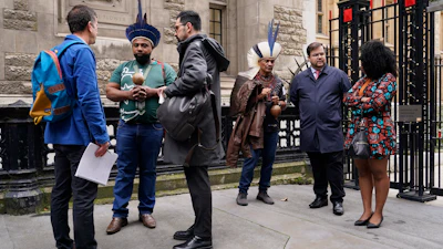 Protesters stand outside the Royal Courts of Justice in London Monday, Oct. 21, 2024, as lawyers representing around 620,000 Brazilians as well as businesses, municipal governments, members of the Krenak indigenous tribe are bringing a multibillion-pound legal action against BHP Group following the collapse of the Fundao dam in November 2015.