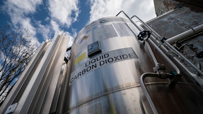 A liquid carbon dioxide containment unit stands outside the fabrication building of Glenwood Mason Supply Company, April 18, 2023, in the Brooklyn borough of New York.
