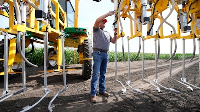 Jake Klocke, of PowerPollen, prepares a pollen applicator, Thursday, Aug. 22, 2024, near Ames, Iowa.