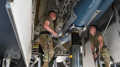 Members of the 28th Aircraft Maintenance Squadron weapons load crew insert an inert joint air-to-surface standoff missile into a B-1B Lancer.