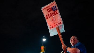 Machinist AJ Nelson, who has worked for Boeing for six years, works the picket line after union members voted to reject a new contract offer from the company, Wednesday, Oct. 23, 2024, in Renton, Wash.