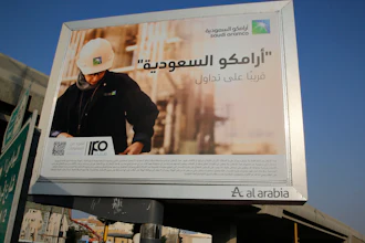 A man walks under a billboard displaying an advertisement for Saudi Arabia's state-owned oil giant Aramco with Arabic reading 'Saudi Aramco, soon on stock exchange' in Jiddah, Saudi Arabia, on Nov. 12, 2019.