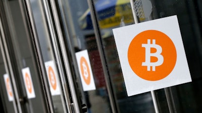 Bitcoin logos are displayed at the Inside Bitcoins conference and trade show on April 7, 2014, in New York.