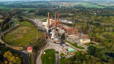 A brief patch of early morning sunlight brightens the landscape around the Greenidge Generation power plant, Oct. 15, 2021, in Dresden, N.Y.
