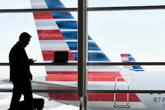 A passenger talks on the phone with American Airlines jets parked behind him at Washington's Ronald Reagan National Airport in Washington, Jan. 25, 2016.
