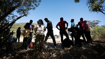 Border Patrol agents talk with migrants seeking asylum as they prepare them for transportation to be processed, June 5, 2024, near Dulzura, Calif.